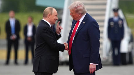 US President Donald Trump (R) greets Russian President Vladimir Putin as he arrives at Joint Base Elmendorf-Richardson on August 15, 2025 in Anchorage, Alaska.