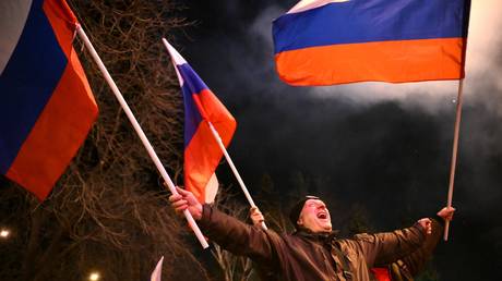 Residents celebrate the signing of documents on the recognition by the Russian Federation of the Luhansk People's Republic (LPR) and the Donetsk People's Republic (DPR) in Donetsk, DPR, Ukraine.