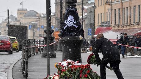 FILE PHOTO: A man lays flowers at a memorial for Russian military blogger Vladlen Tatarsky, who was killed in a bomb attack in Saint Petersburg, Russia, April 2, 2023